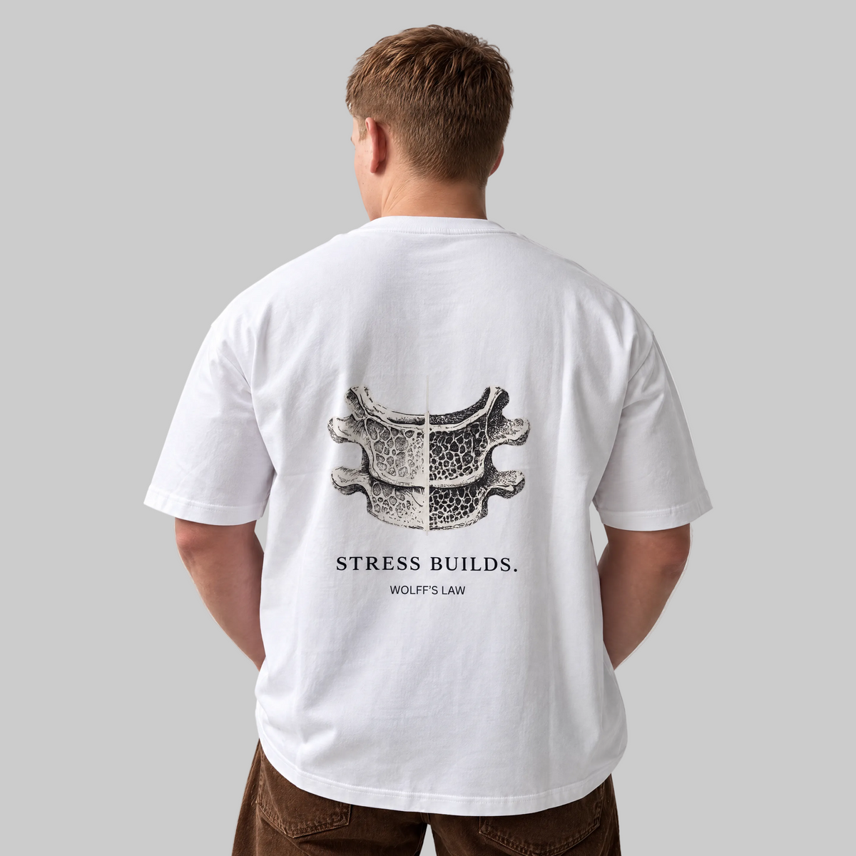 STRESS BUILDS. Tee in White, back print, on the model. Model wears XL • 5'11" • 216 lb