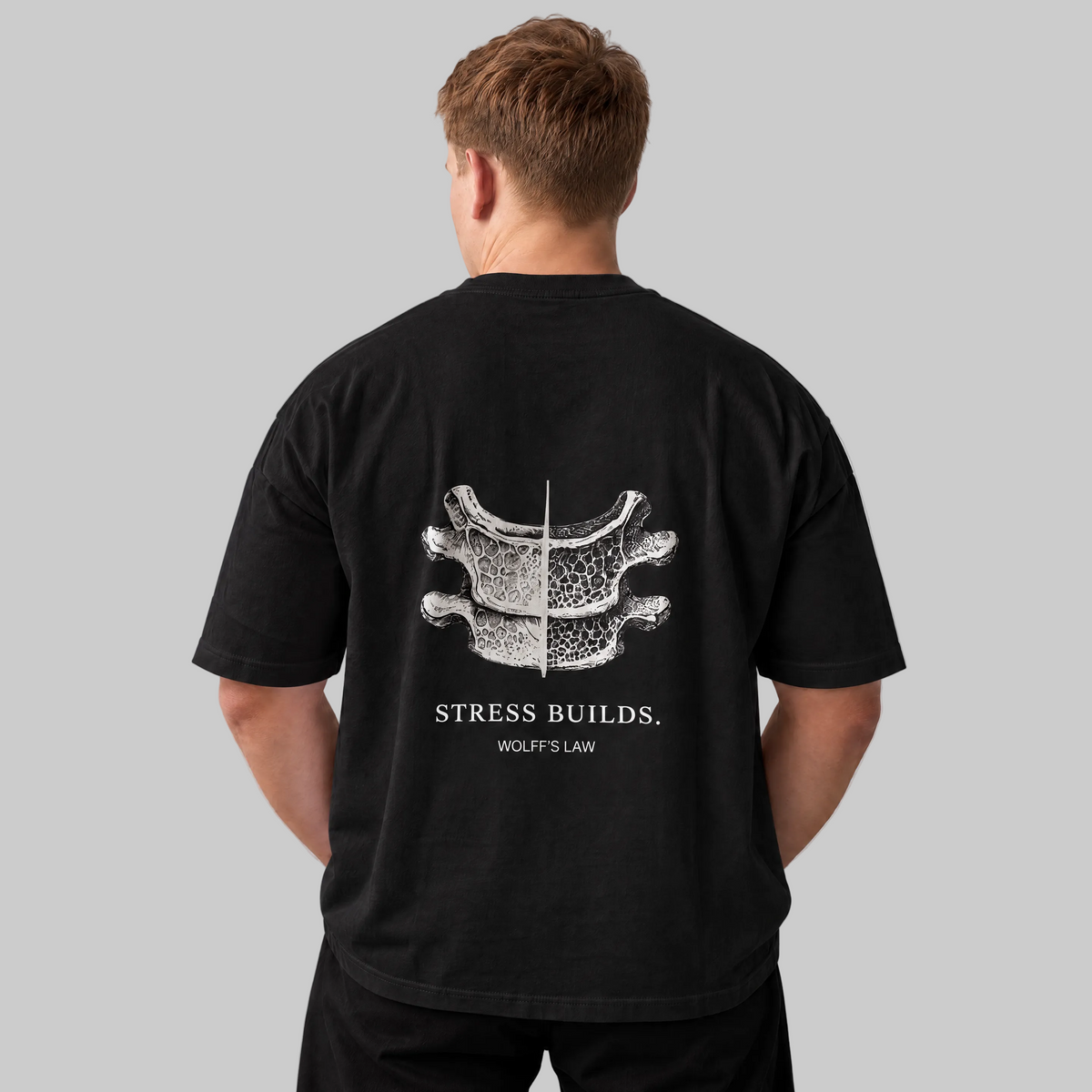 STRESS BUILDS. Tee in Black, back print, on the model. Model wears XL • 5'11" • 216 lb