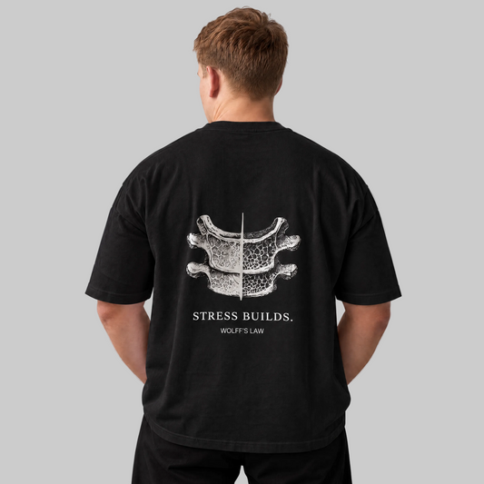 STRESS BUILDS. Tee in Black, back print, on the model. Model wears XL • 5'11" • 216 lb